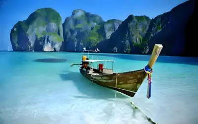 a boat in the water in front of a beach at XX BAO Patong Beach Phuket - เบาป่าตองบีช in Patong Beach