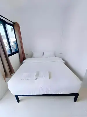 a white bed in a room with a window at XX BAO Patong Beach Phuket - เบาป่าตองบีช in Patong Beach