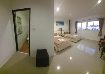 a large room with two beds and a mirror at Athome Hotel Nanai 8 in Patong Beach