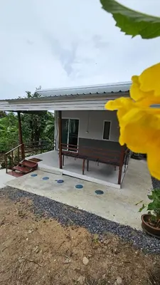a house with a bench in front of it at Cozy 1-Bedroom Bungalow with Shared Pool in Rawai in Nai Harn Beach