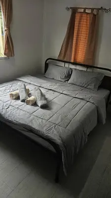 a bed with two pillows on it in a bedroom at Cozy 1-Bedroom Bungalow with Shared Pool in Rawai in Nai Harn Beach