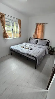 a bedroom with a bed in a room with a window at Cozy 1-Bedroom Bungalow with Shared Pool in Rawai in Nai Harn Beach