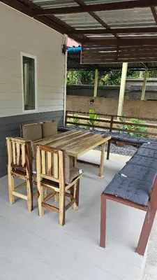 a wooden table and two chairs on a patio at Cozy 1-Bedroom Bungalow with Shared Pool in Rawai in Nai Harn Beach