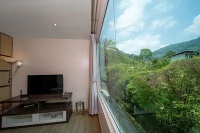 a room with a window with a view of a mountain at A New Experience of Private Vacation and Work in Patong in Patong Beach