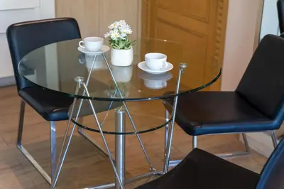 a glass table with two chairs and two cups and flowers at A New Experience of Private Vacation and Work in Patong in Patong Beach