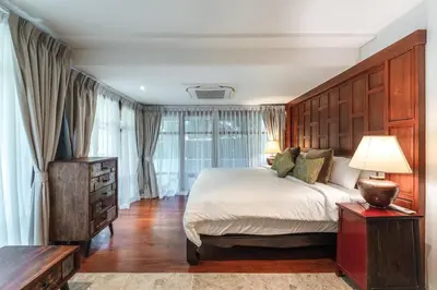 a bedroom with a large bed with a wooden headboard at Villa Gecko with sea view pool, walk to Beach & Restaurants in Surin Beach