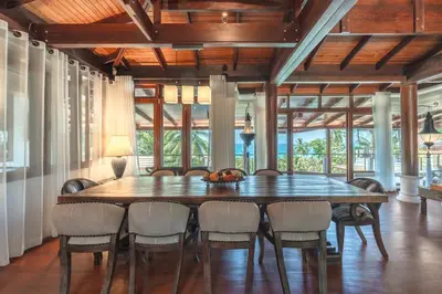a dining room with a large wooden table and chairs at Villa Gecko with sea view pool, walk to Beach & Restaurants in Surin Beach