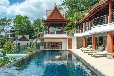 a villa with a swimming pool in front of a house at Villa Gecko with sea view pool, walk to Beach & Restaurants in Surin Beach