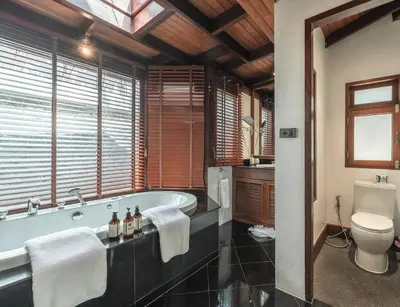 a bathroom with a bath tub and a toilet at Villa Gecko with sea view pool, walk to Beach & Restaurants in Surin Beach
