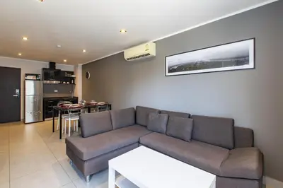 a living room with a couch and a kitchen at Modern Condo - 1BR T1-201 in Ban Klang