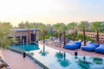 a resort pool with chaise lounge chairs and palm trees at Tropics Kamala 2BR Apartment CTG L602-3, Several Pools, Gym & Rooftop in Kamala Beach