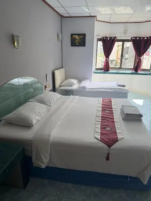 two beds in a room with two beds sidx sidx sidx at Karon Cove at Seabreeze Inn in Karon Beach