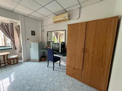 a living room with a large wooden cabinet and a television at Karon Cove at Seabreeze Inn in Karon Beach