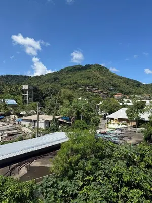 a view of a town with a mountain in the background at Karon Cove at Seabreeze Inn in Karon Beach