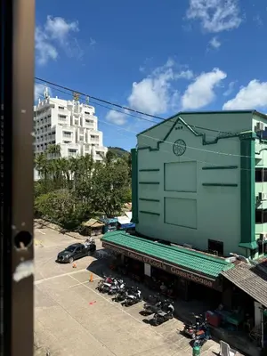 a building with a clock on it in a parking lot at Karon Cove at Seabreeze Inn in Karon Beach