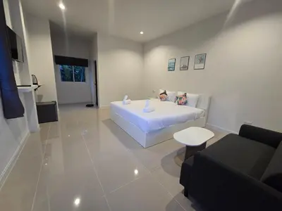 a bedroom with a large white bed and a couch at แวะพักสเตย์โฮสเทล Wae Phak Stay Hostel in Ban Huai Sai