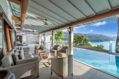 an open living room with a view of the water at Villa Amankara in Phuket Town