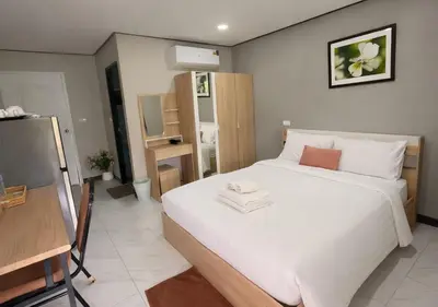 a bedroom with a large white bed in a room at MBB House in Thalang