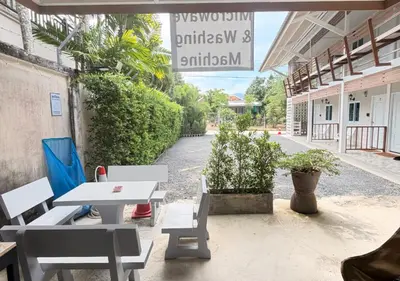 a patio with a table and chairs on a street at MBB House in Thalang