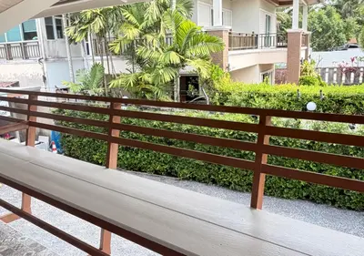 a wooden bench sitting in front of a building at MBB House in Thalang