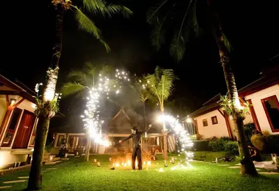 a person standing in a yard at night with lights at Villa Talaefun - Luxury Oceanfront Fully Serviced in Kamala Beach