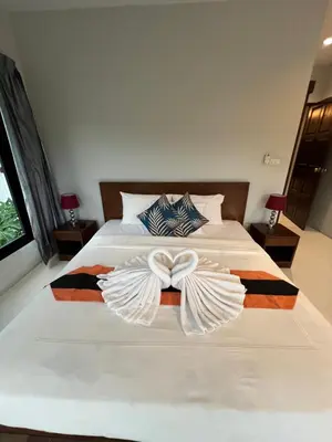 a bedroom with a bed with a bow on it at Nern khao Guesthouse in Kamala Beach