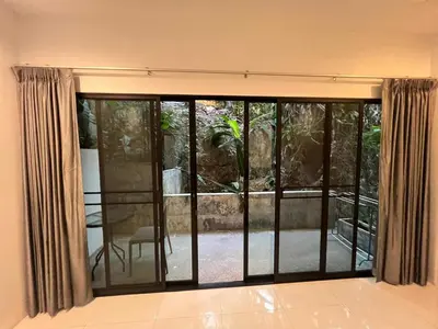 a room with a sliding glass door with a patio at Nern khao Guesthouse in Kamala Beach