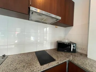 a small kitchen with a microwave and a counter at Nern khao Guesthouse in Kamala Beach