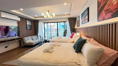 a hotel room with two beds and a flat screen tv at Charming home patong in Patong Beach