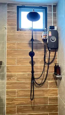 a shower in a bathroom with a phone on a wall at Charming home patong in Patong Beach