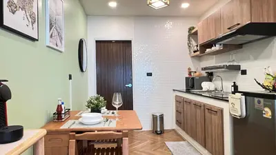 a small kitchen with a table and a refrigerator at Charming home patong in Patong Beach