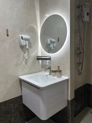 a bathroom with a white sink and a mirror at Kates cozy place in Mai Khao Beach