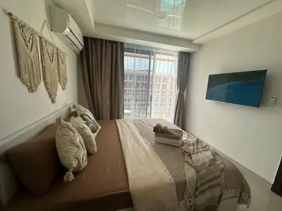 a bedroom with a large bed with a window at Kates cozy place in Mai Khao Beach