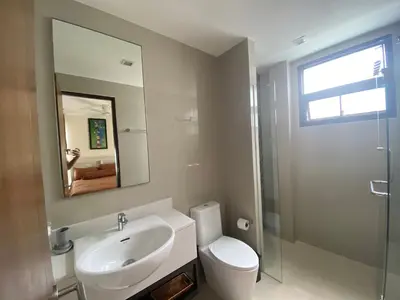 a bathroom with a sink and a toilet and a mirror at 4bdr Villa with gym and pool in Laguna #168 in Laguna Phuket