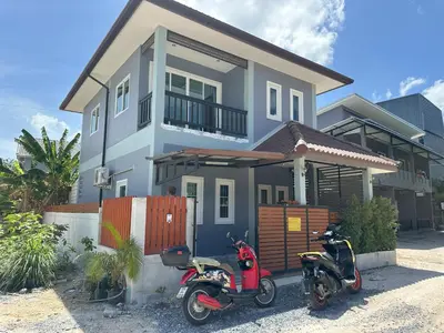 two scooters parked in front of a house at Family House in Bang Tao in Ban Thalat Choeng Thale
