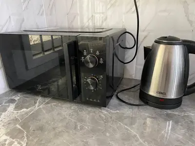 a microwave and a toaster oven on a counter at Family House in Bang Tao in Ban Thalat Choeng Thale