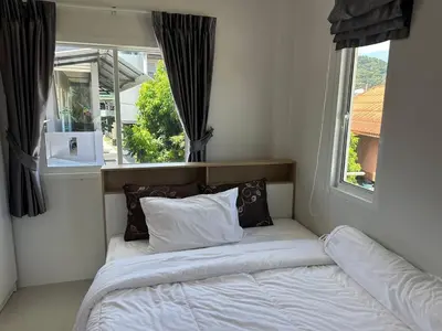 a bed in a room with a window at Family House in Bang Tao in Ban Thalat Choeng Thale