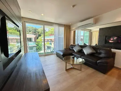 a living room with a leather couch and a flat screen tv at 1 bedroom Suite Seaview In Kalim in Patong Beach