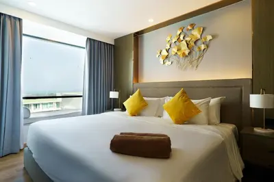 a bedroom with a large white bed with yellow pillows at View 2Bdr Lux Life Rawai in Rawai Beach