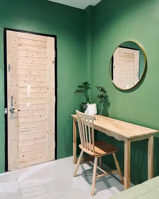 a room with a wooden table and a mirror at Midori Rawai Hotel in Ban Saiyuan (1)