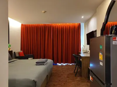 a hotel room with a bed and a red curtain at 7 Floor - Pool view Studio room at TBHR near Kata beach in Kata Beach