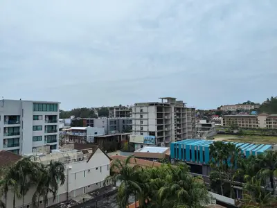 a city with tall buildings and palm trees at 7 Floor - Pool view Studio room at TBHR near Kata beach in Kata Beach