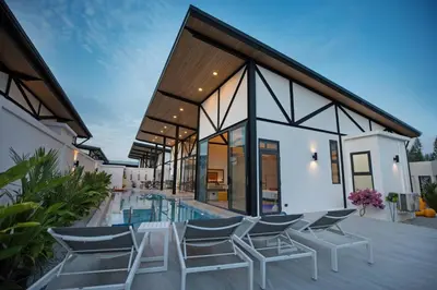 a house with a swimming pool and chairs at 3BR Villa Sunset Garden 12 - Private 18m Pool in Rawai in Rawai Beach