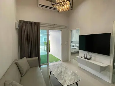 a living room with a couch and a flat screen tv at The Rich Villas Palai in Chalong