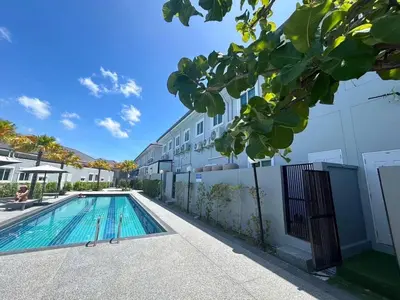 a swimming pool in front of a building at The Rich Villas Palai in Chalong