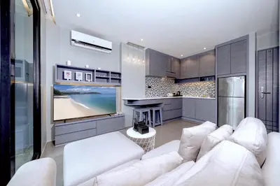 a living room with a white couch and a television at Tropics Hill View Apartment CTG L706 at Kamala Residence, Top Amenities, Close to the Beach and Fantasea in Kamala Beach