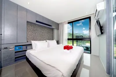 a bedroom with a large bed with a red flower on it at Tropics Hill View Apartment CTG L706 at Kamala Residence, Top Amenities, Close to the Beach and Fantasea in Kamala Beach