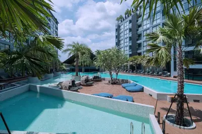 a swimming pool with lounge chairs and palm trees next to a building at Green View Suite CTG P210 at Tropics Kamala Residence near Fantasea in Kamala Beach