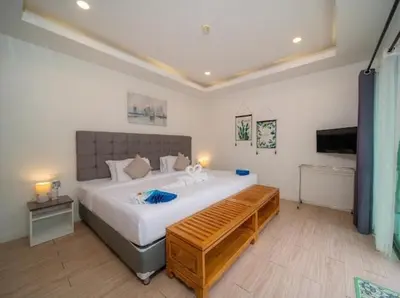 a bedroom with a large bed with a wooden bench at 4Luxury Pool Villa 4 Bedrooms Private Pool Kitchen in Ban Bang La