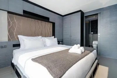 a bedroom with a large white bed with towels on it at Tropics Kamala Hill View Studio CTG P613 near Beach and Fantasea in Kamala Beach